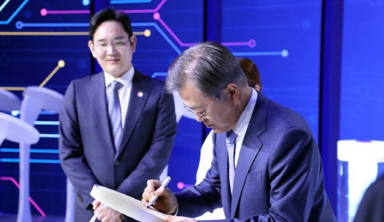 이재용 삼성전자 부회장이 지난 4월 30일 시스템 반도체 비전 선포식이 열린 삼성전자 화성캠퍼스 부품연구동(DSR)에서 열린 7나노 EUV(극자외선) 공정 스마트폰 애플리케이션 프로세서(AP) 출하식에서 문재인 대통령의 서명을 지켜보고 있다. <연합뉴스>